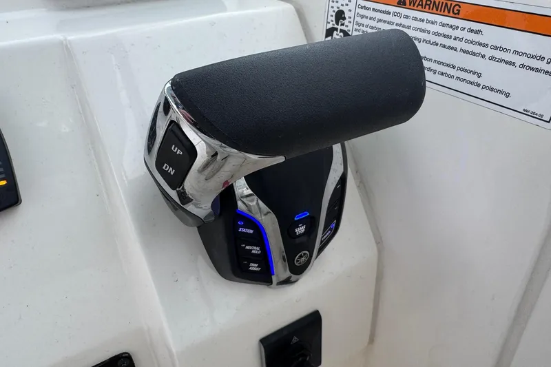 Slide: The Image of Throttle control of 2024 Cobia 240 Dual Console boat with warning label. - 26