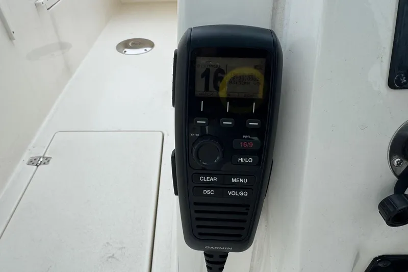 Slide: The Image of Garmin marine radio on 2024 Cobia 240 Dual Console boat dashboard. - 28