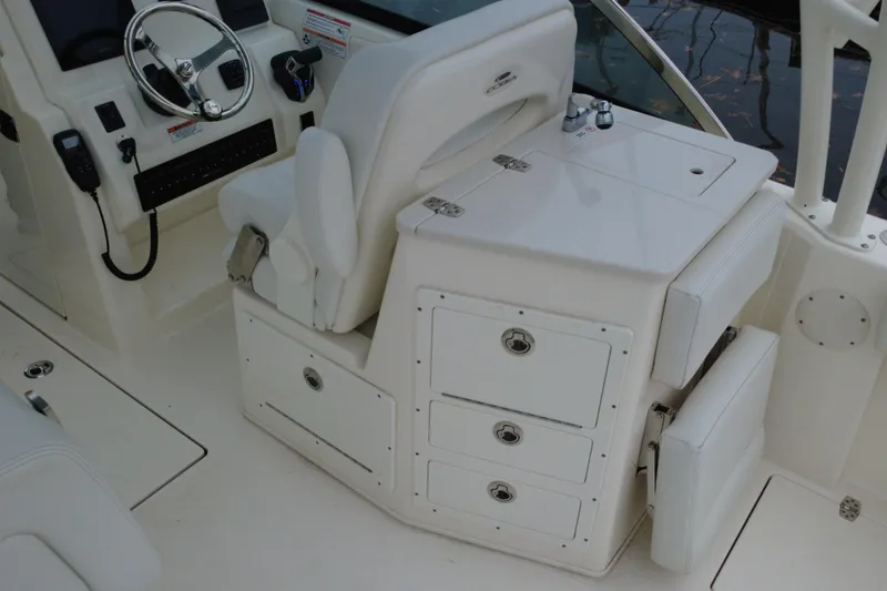 Slide: The Image of 2024 Cobia 240 Dual Console boat interior with steering wheel and storage compartments. - 5