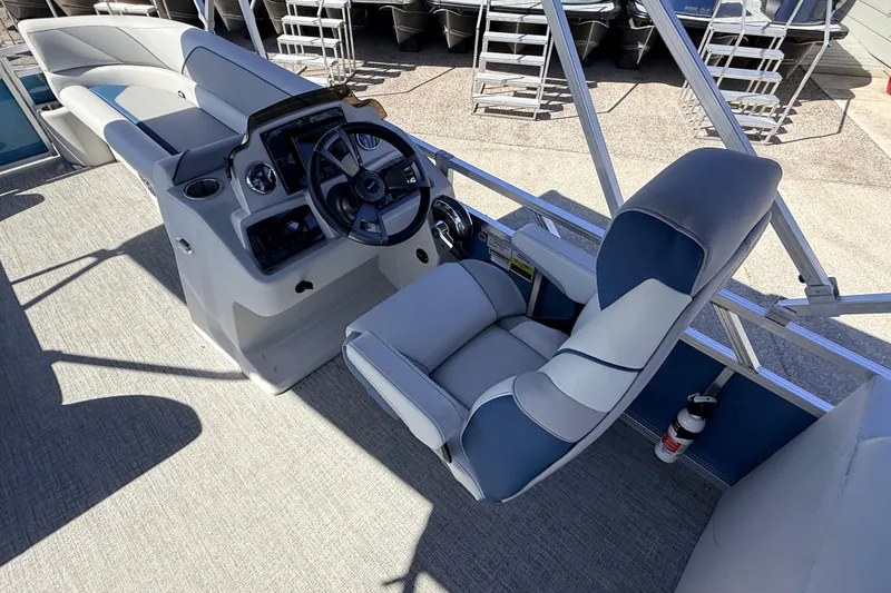 Slide: The Image of 2026 Avalon 2385 Venture 85 Quad Lounger boat interior with steering console and seating. - 21