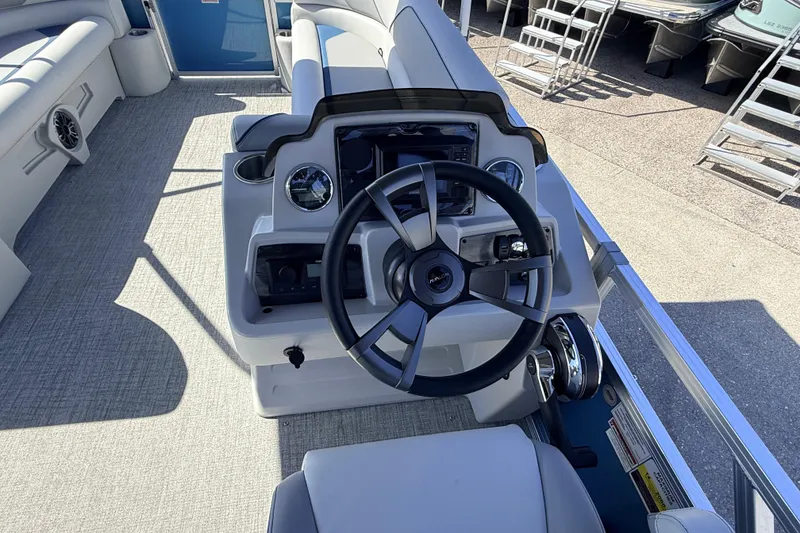 Slide: The Image of 2026 Avalon 2385 Venture 85 Quad Lounger boat helm with modern steering and controls. - 22