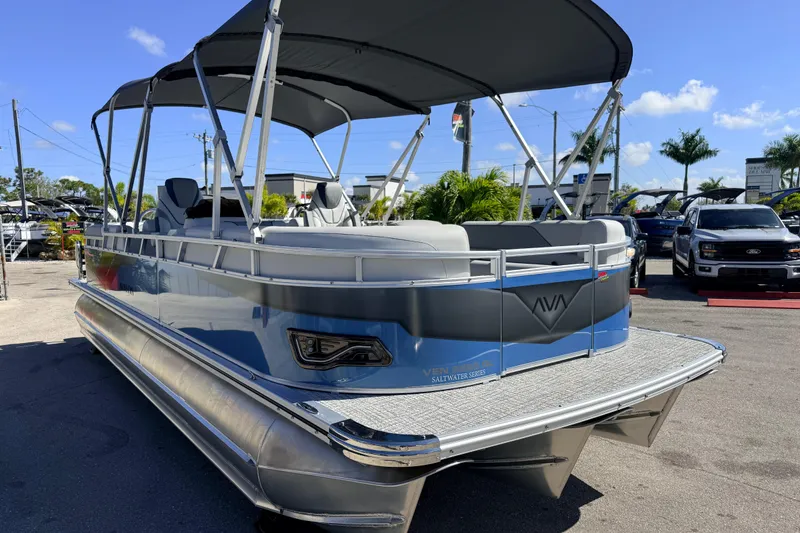 Slide: The Image of 2026 Avalon 2385 Venture 85 Quad Lounger Tri Toon boat with canopy, parked outdoors. - 4