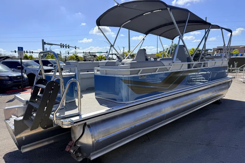 Slide: The Image of 2026 Avalon 2385 Venture 85 Quad Lounger Tri Toon, high-performance pontoon boat in parking lot. - 6