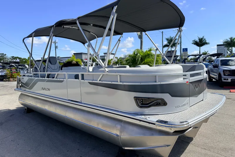 Slide: The Image of 2026 Avalon 2385 Venture 85 Tri Toon boat with canopy, parked outdoors. - 6