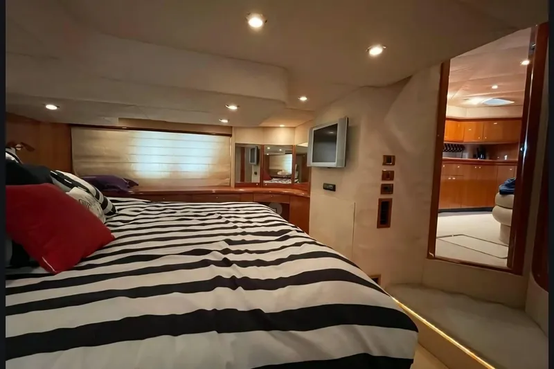 Slide: The Image of Luxurious 2004 Sunseeker Predator 56 yacht bedroom with striped bedding and modern amenities. - 17