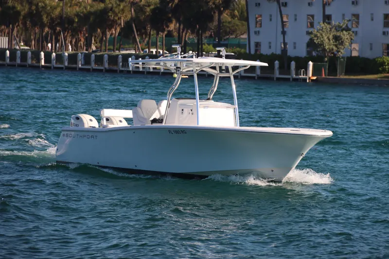 Slide: The Image of 2016 Southport 272 TE boat cruising on blue water near a shoreline. - 15