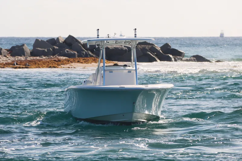 Slide: The Image of 2016 Southport 272 TE boat navigating ocean waves near rocky shoreline. - 18