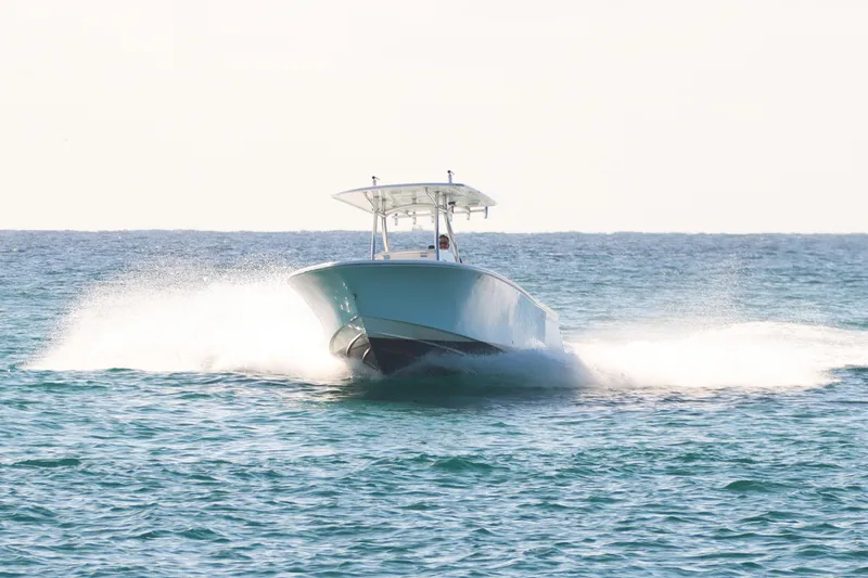 Slide: The Image of 2016 Southport 272 TE boat cruising on open sea, creating a splash. - 20