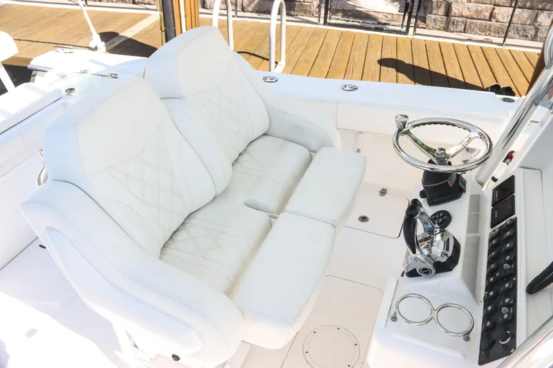 Slide: The Image of 2016 Southport 272 TE boat cockpit with white seating and steering wheel. - 27