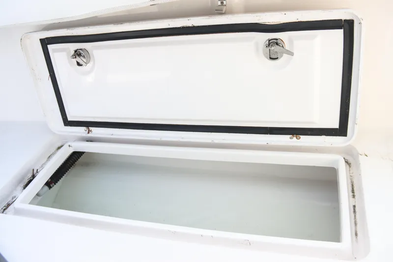Slide: The Image of Open storage compartment on a 2016 Southport 272 TE boat, featuring secure latches. - 28