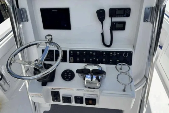 Slide: The Image of 2016 Southport 272 TE boat helm with steering wheel, controls, and navigation equipment. - 3