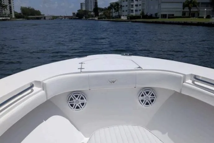 Slide: The Image of 2016 Southport 272 TE boat on a scenic waterway with modern buildings. - 7