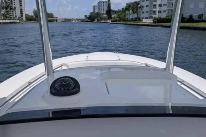 Slide: The Image of 2016 Southport 272 TE boat navigating a scenic waterway with buildings in the background. - 8