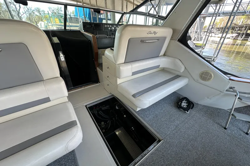 Slide: The Image of 1986 Sea Ray 390 Express Cruiser interior with open engine hatch, showcasing seating and helm. - 15