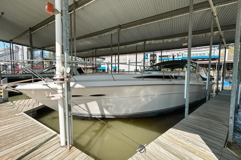 The Image of 1986 Sea Ray 390 Express Cruiser docked in a covered marina. - 2