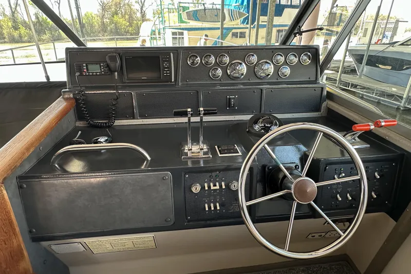 Slide: The Image of 1986 Sea Ray 390 Express Cruiser helm with steering wheel, gauges, and controls. - 25