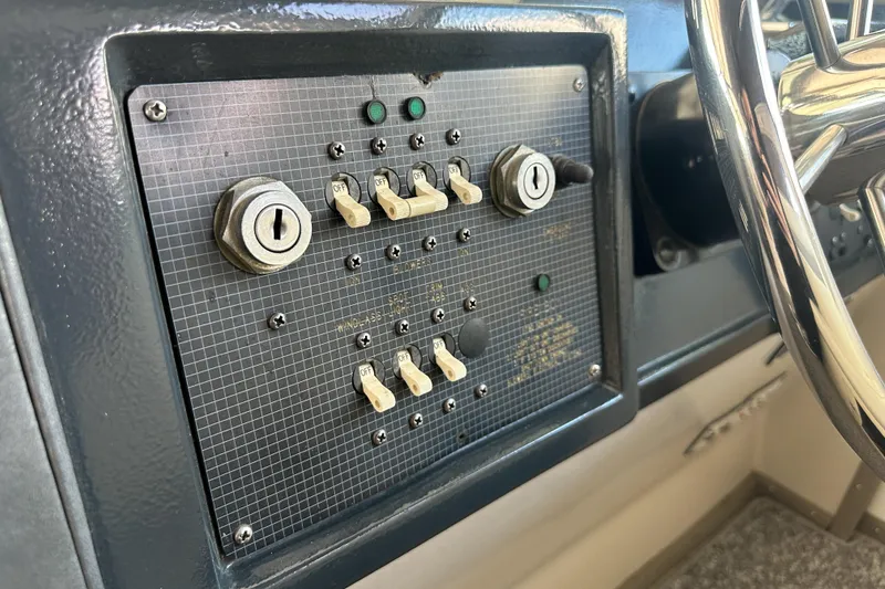 Slide: The Image of Control panel of 1986 Sea Ray 390 Express Cruiser with switches and key slots. - 26