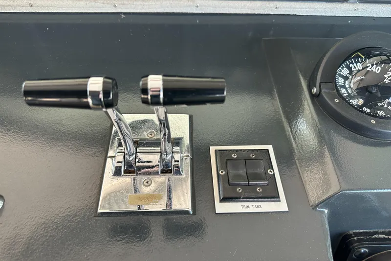 Slide: The Image of Control panel of 1986 Sea Ray 390 Express Cruiser with throttle levers and compass. - 29