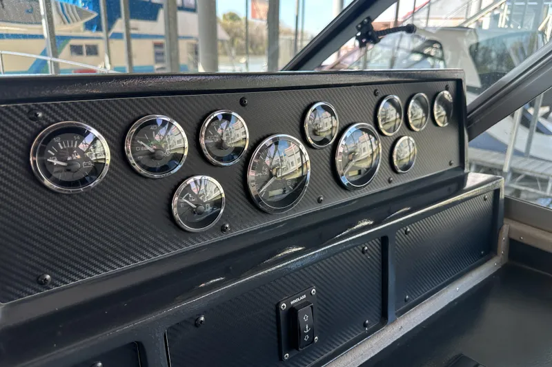 Slide: The Image of Dashboard of a 1986 Sea Ray 390 Express Cruiser with multiple gauges and controls. - 31