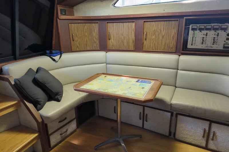 Slide: The Image of Interior of 1986 Sea Ray 390 Express Cruiser with seating and navigation table. - 33
