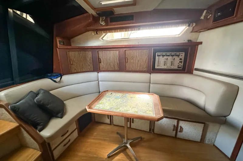 Slide: The Image of 1986 Sea Ray 390 Express Cruiser interior with cozy seating and navigation table. - 35