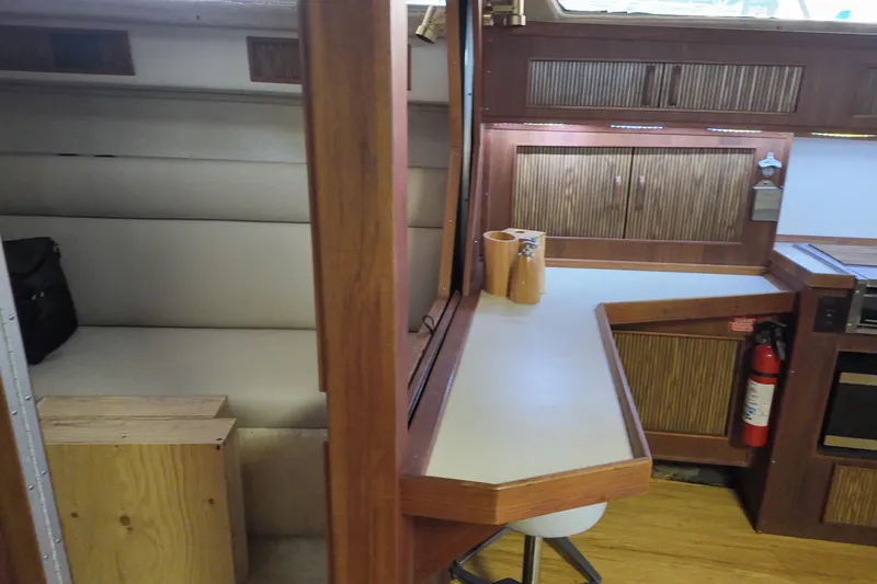 Slide: The Image of 1986 Sea Ray 390 Express Cruiser interior with wood cabinetry and seating area. - 40