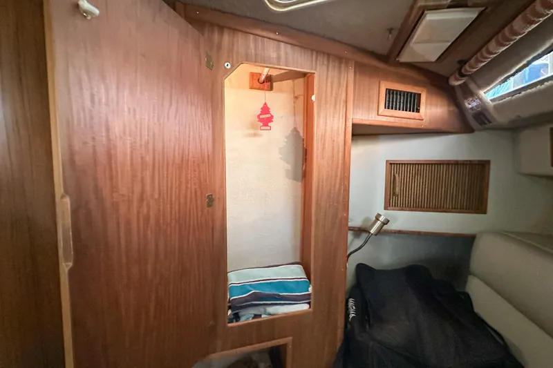 Slide: The Image of 1986 Sea Ray 390 Express Cruiser cabin interior with wood paneling and storage space. - 42