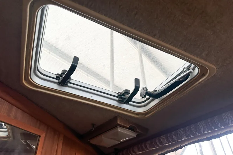 Slide: The Image of 1986 Sea Ray 390 Express Cruiser cabin skylight with open latches. - 43