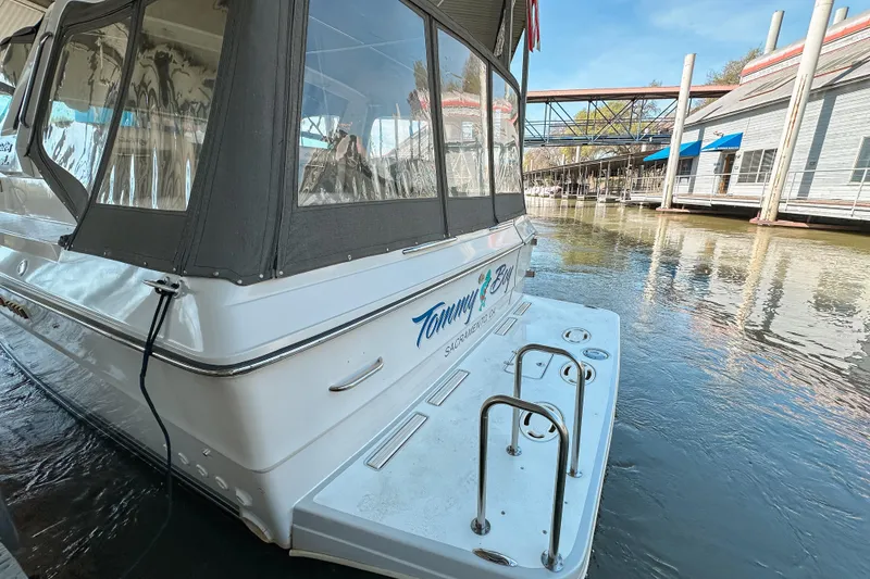 Slide: The Image of 1986 Sea Ray 390 Express Cruiser docked at marina, rear view with water reflections. - 5