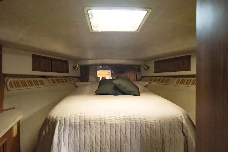 Slide: The Image of Cozy cabin interior of 1986 Sea Ray 390 Express Cruiser with bed and pillows. - 51