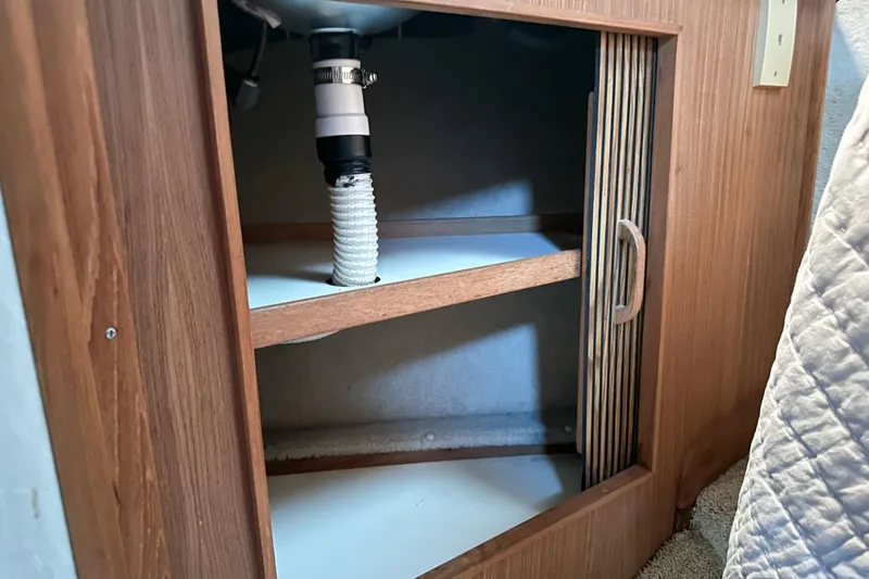 Slide: The Image of 1986 Sea Ray 390 Express Cruiser interior cabinet with plumbing visible. - 55