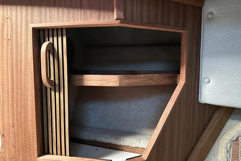 Slide: The Image of 1986 Sea Ray 390 Express Cruiser interior wooden cabinet with open door. - 57