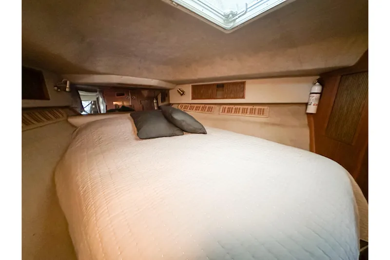 Slide: The Image of Interior cabin of 1986 Sea Ray 390 Express Cruiser with cozy bed and pillows. - 59