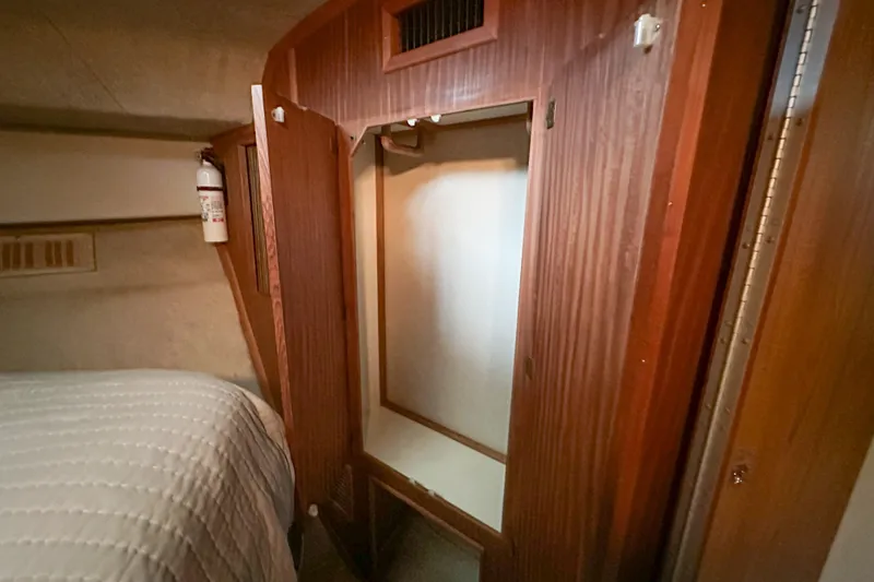 Slide: The Image of 1986 Sea Ray 390 Express Cruiser interior with wooden closet and bed. - 61