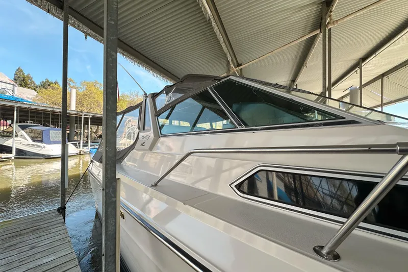 Slide: The Image of 1986 Sea Ray 390 Express Cruiser docked under a covered marina. - 8