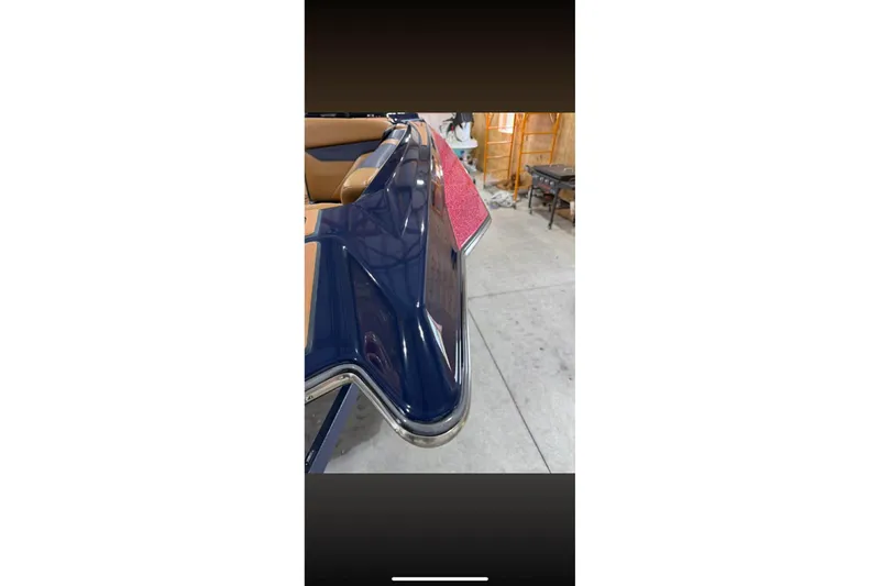 Slide: The Image of 2021 Axis A24 boat with blue exterior and tan interior in a garage setting. - 5