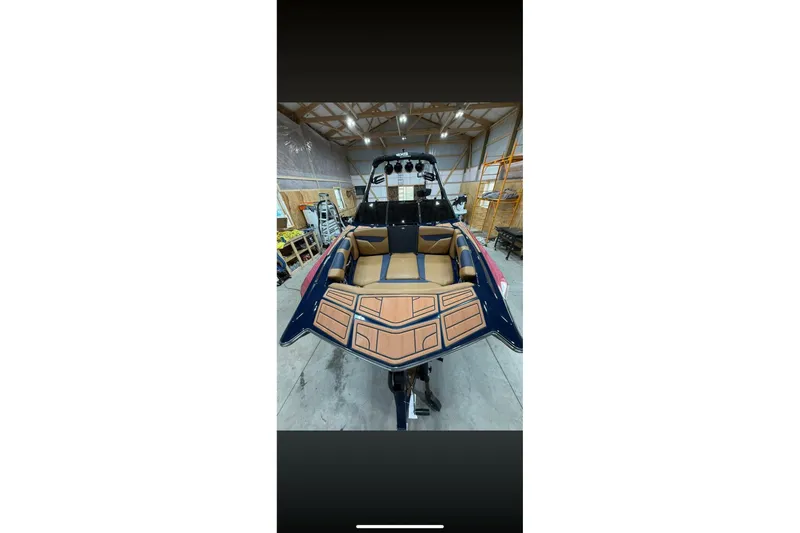 Slide: The Image of 2021 Axis A24 boat with tan seating in a warehouse setting. - 7