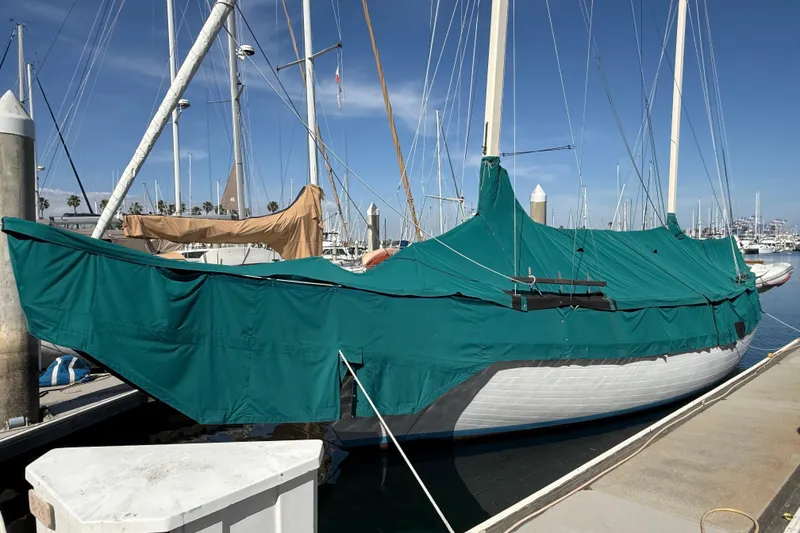 Slide: The Image of Vintage 1965 sailboat in marina, surrounded by yachts and calm water reflections. - 1