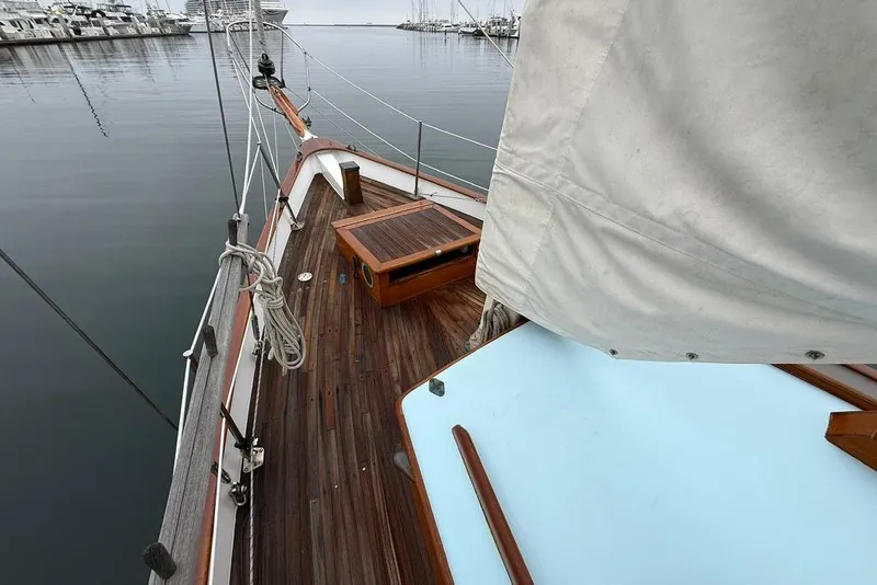 Slide: The Image of Vintage 1965 sailboat deck with wooden finish, docked in a calm marina. - 11