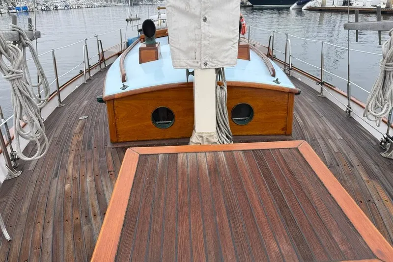 Slide: The Image of Vintage 1965 sailboat with wooden deck and cabin, docked at a marina. - 16