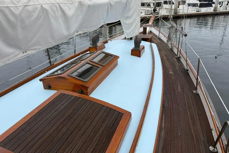 Slide: The Image of Vintage 1965 sailboat deck with wooden accents and marina background. - 17