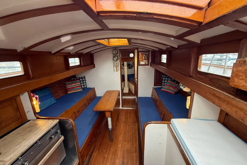 Slide: The Image of Interior of a 1965 Vintage 34 boat with wooden furnishings and blue cushions. - 22