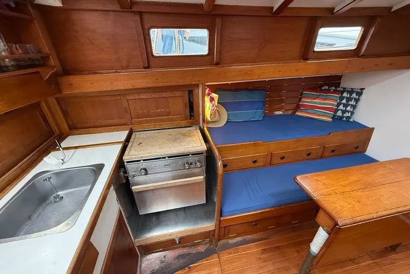 Slide: The Image of Vintage 1965 boat interior with wooden cabinetry, compact kitchen, and cozy seating area. - 25