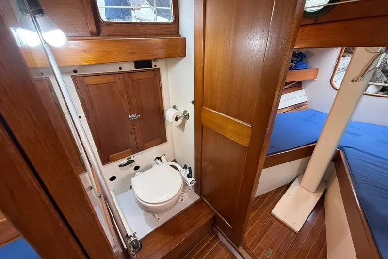 Slide: The Image of Vintage 1965 boat interior with wooden cabinetry, toilet, and blue cushioned seating. - 27