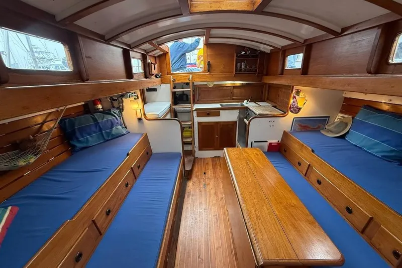 Slide: The Image of Vintage 1965 boat interior with wooden furnishings, blue cushions, and compact kitchen area. - 28