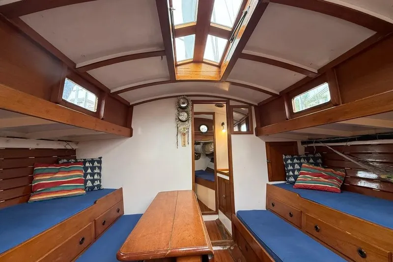 Slide: The Image of Vintage 1965 boat interior with wooden furnishings and blue cushions, featuring a skylight. - 30