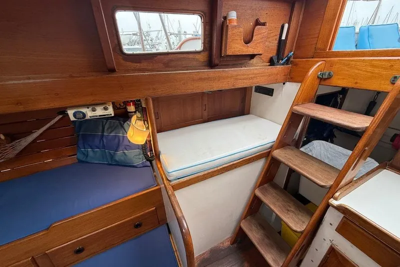 Slide: The Image of Interior of a 1965 Vintage 34 boat with wooden furnishings and cozy sleeping area. - 33