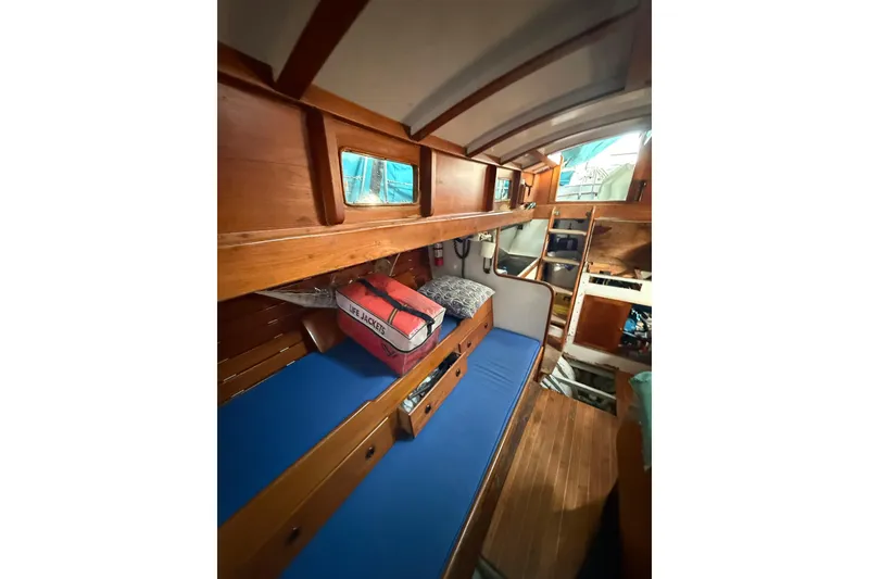 Slide: The Image of Vintage 1965 sailboat deck with wooden details and rigging, docked in a calm marina. - 4