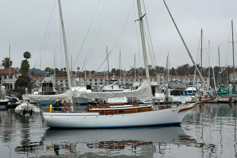 Slide: The Image of Vintage 1965 sailboat deck with wooden accents and skylights on calm water. - 5