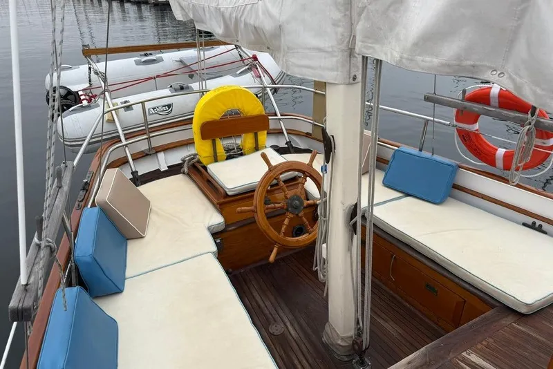 Slide: The Image of Vintage 1965 sailboat interior with wooden steering wheel and cushioned seating. - 8